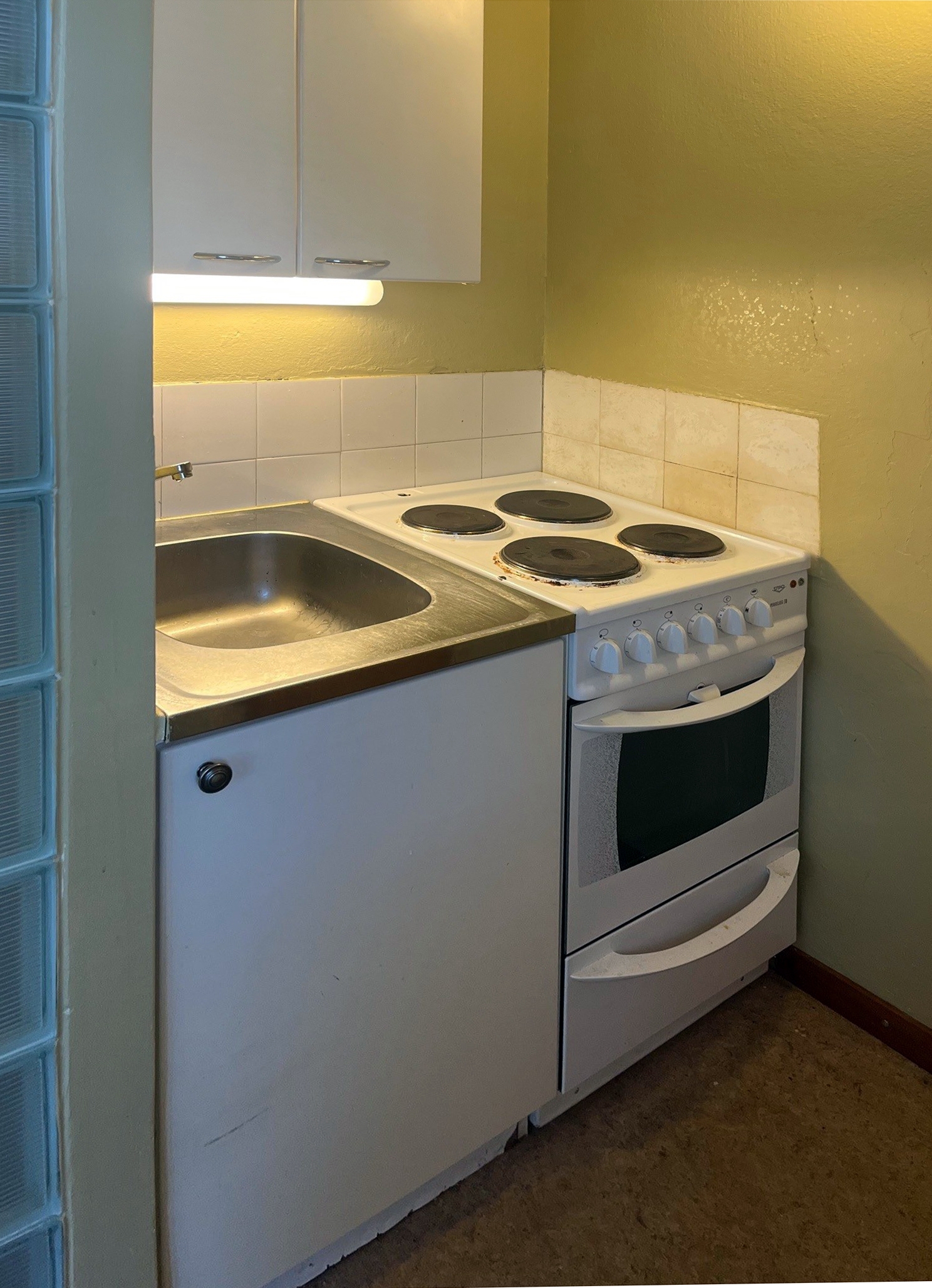 Keittokomeron allaskaapissa valkea lastulevyovi.