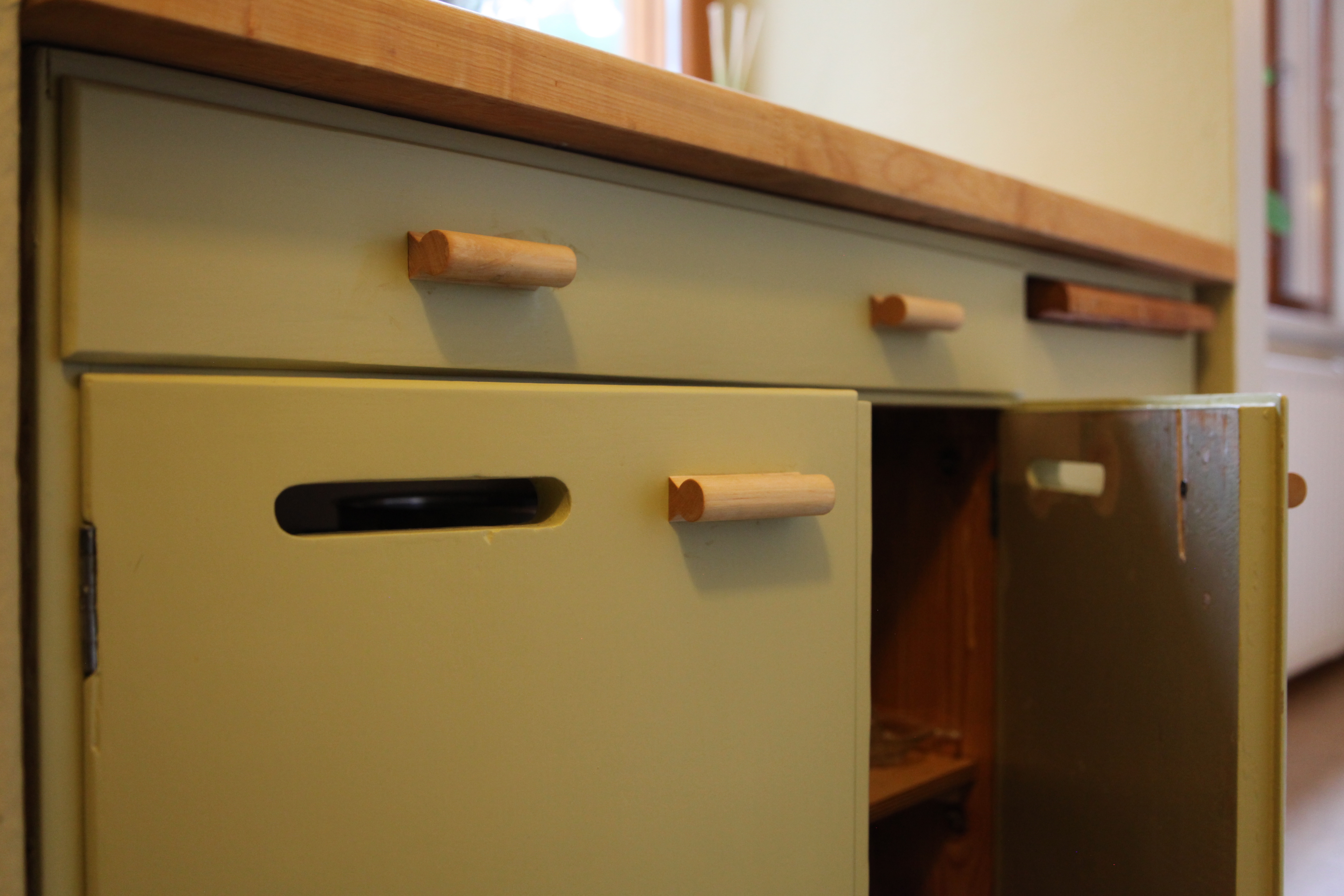 Kunnostettu alakaappi paikalleen asennettuna läheltä nähtynä. Avoimena olevan oven vanha sisäpinta näkyy.