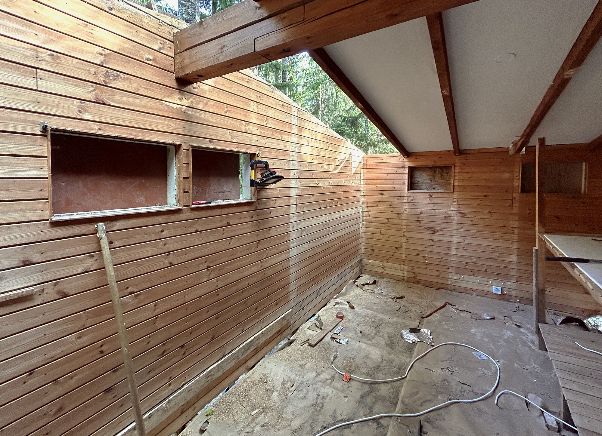 Kuva mökin sisätilasta purkutöiden aikana, osa kattorakenteesta on poistettu.